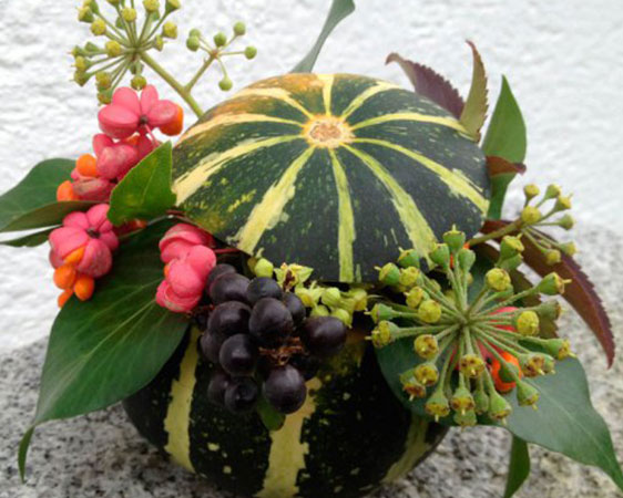 Grünes Kürbisgesteck mit Beeren
